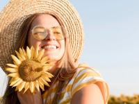 girl holding sunflower in sunlight