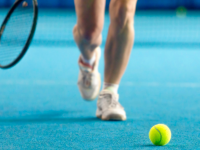 Female tennis player walking towards tennis ball