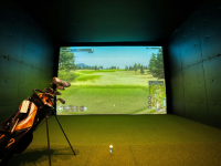 Indoor virtual golf screen with a bag of golf clubs