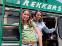 two students smiling by a bus