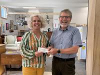 J.P. Fecteau of the West Bay Rotary Satellite Club presents a $1,694 donation to Tia Anderson, Executive Director of Midcoast Habitat for Humanity, inside Midcoast Habitat’s new ReStore location in Rockport. The donation will support a Habitat home in Thomaston.