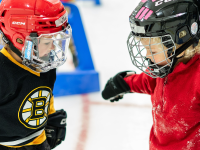 Two young skaters having fun learning to skate on ice.