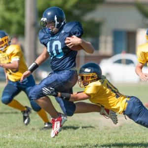 Oceanside's Chris Christians breaks a tackle and goes all the way for his first of three touchdowns on the day. Photo by Ron Hawkes