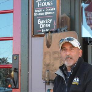David Robichaud sits outside Cappy's Chowder House on the famous bench, which accommodates locals and visitors for conversation. (Photo by Lynda Clancy)