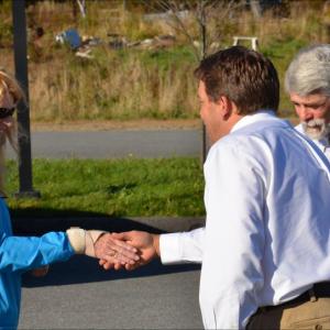 Marianne Smith shakes hands with Stephan Keenan, of Keenan Auction Company, just before going to cast the winning bid at the foreclosure auction of Farmers Fare, on the corner of Cross Street and Route 90 in Rockport on Oct. 18. Her husband, Stuart, is to her left. (Photo by Lynda Clancy)