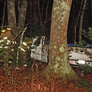 A pickup truck with a crushed roof sits in the woods off outer Washington Street (Route 105) Friday morning. (Photo by Holly S. Edwards)
