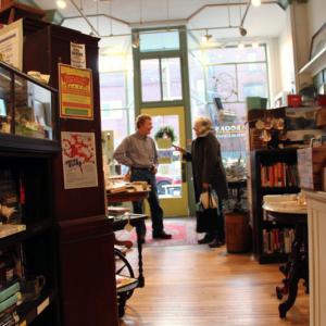 Jean Watts of Glenburn talks to Bella Books co-owner Gary Guida on Thursday. The store is one of many in downtown Belfast opening at 6 a.m. this Saturday for the annual Early Bird Sale. (Photo by Wes Sterrs)
