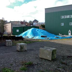 A pile of contaminated soil removed from the path of the planned Belfast Harbor Walk sits near the area where it was recently removed. The route of the Harbor Walk is in line with the temporary cement bollards in the foreground.