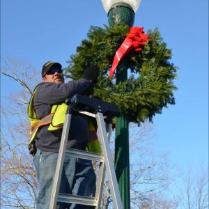 Camden town employee Tracy Harford was decorating the town Nov. 20 with fresh wreaths made by the Camden Garden Club. (Photo by Lynda Clancy)