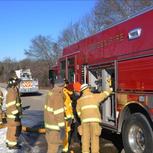 Camden firefighters Mary Stiehler, Cheyne Hansen, Tom Bland and Robert Stiehler. John Foxx, in the orange hat, is from Minute Fire and Rescue Apparatus, Inc., in Walpole, Mass., and is training Camden firefighters on Engine 4 features. (Photos by Lynda Clancy)