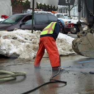A Maine Water employee uses a jackhammer on Union Street, in front of Camden Exxon, to work on a major water main break discovered Sunday morning in front of Camden Exxon. (Photo by Holly S. Edwards)