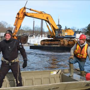 Toby Wincklhofer prepares to dive into Camden Harbor Jan. 11 to release line that had tangled with a tug's propeller. Jamie Dever takes him over to the spot in his skiff. (Photo by Lynda Clancy)