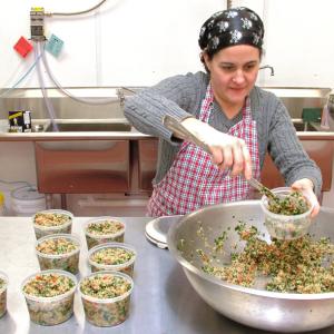 Julie Romano, of Julie Ann's Outrageous! Foods, fills containers with quinoa tabouli in the commercial kitchen space she rents at Coastal Farms Food Processing. (Photo by Ethan Andrews) Julie Romano, of Julie Ann's Outrageous! Foods, fills containers with quinoa tabouli in the commercial kitchen space she rents at Coastal Farms Food Processing. (Photo by Ethan Andrews)
