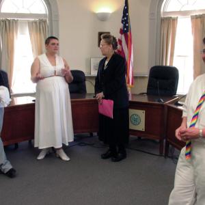 Gabrielle Eiholzer, far right, and Opal Ash, second from left, dressed in white with rainbow accents for their wedding at City Hall, Feb. 25, the first marriage of a same-sex couple in Belfast. (Photo by Ethan Andrews)