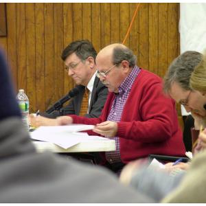 David Italiaander, center in red, testifies against the tank Wednesday night. Italiaander is flanked by attorneys Ed Bearor, left, and Steve Hinchman, right. (Photo by Ethan Andrews)