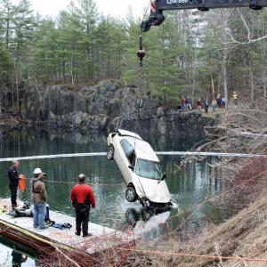 A car that was driven by Christan Marston of Appleton and crashed into Eells Quarry on Main Street, near Simonton Corner, in Rockport, is lifted out of the water by an Art Henry Crane while Dallas Fields, Wes Greenrose and Ben Bruno of Fields Dive Service look on. (Photo by Holly S. Edwards)
