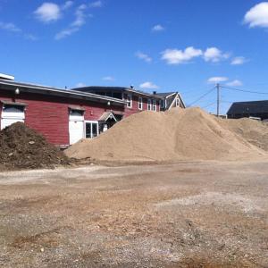 Piles of mulch, sand and rough fill on Sunday obscured the city-owned building most recently home to the Belfast Maskers. The property is being used as a staging area for materials for the Belfast Harbor Walk project, which broke ground last week. (Photo by Ethan Andrews) Piles of mulch, sand and rough fill on Sunday obscured the city-owned building most recently home to the Belfast Maskers. The property is being used as a staging area for materials for the Belfast Harbor Walk project, which broke ground last week. (Photo by Ethan Andrews)