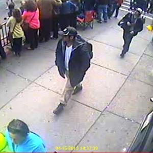 A still image of two men, Suspect 1 in a black baseball hat and Suspect 2 in a backwards white baseball hat, walking alone the Boston Marathon route April 15. (Courtesy FBI)