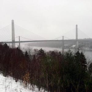 The observatory of the Penobscot Narrows Bridge, seen from an overlook on Route 1 in Prospect, will open later this year due to the continuing demolition of the old Waldo-Hancock Bridge, visible behind the newer bridge. (Photo by Ethan Andrews)