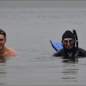 Stan Grunder and Matt Heath are racing tomorrow in the Run For Your Life 5K obstacle course adventure race at the Camden Snow Bowl. They were traversing Hosmer Pond Friday afternoon, May 24. Heath was checking out the bottom with his goggles. The water temperature was frigid, said Grunder, somewhere in the 40s, as he swam gamely on. (Photo by Lynda Clancy)