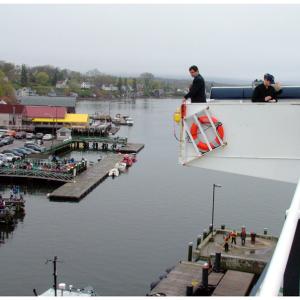 Capt. David Gelinas of the Penobscot Bay & River Pilots Association looks down at the water in Castine Harbor from the upper deck of Maine Maritime Academy's Training Ship State of Maine for clues about the direction of the tide. (Photo by Ethan Andrews)