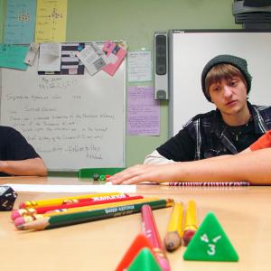 Stephen Colby, center, advises Casey Baxter, right, in a game of Pathfinder during a weekly session hosted by the Game Loft at Mount View Middle School. Colby, a longtime member of the Belfast-based after school program built around non-electronic gaming. Mount View student Tyler Cross, left, would later take over for Colby to lead a younger group. (Photo by Ethan Andrews)