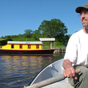 Maynard Haslett, of Washington, rows a dingy out to his 30-foot riverboat, "Shanty," anchored in the Passagassawakeag River in Belfast. (Photo by Ethan Andrews)