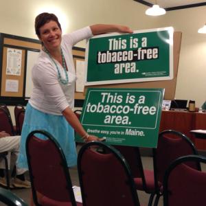 Beth Ward, acting director of Camden Parks and Recreation, with the new, and old, no-smoking signs that will go up around town. (Photo by Lynda Clancy)