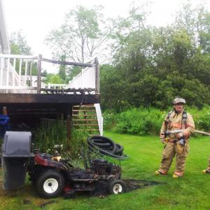 Thomaston Fire Department Capt. Tony Leo and firefighters extinguish a fire that demolished a lawnmower tractor and crept up the side of a deck July 29. (Photo courtesy of Tony Leo)
