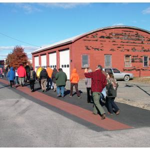 Harbor Walk grand opening attendants pass in front of one of several commercial properties that account for an inland detour on the mostly-waterfront path. (Photo by Ethan Andrews) 