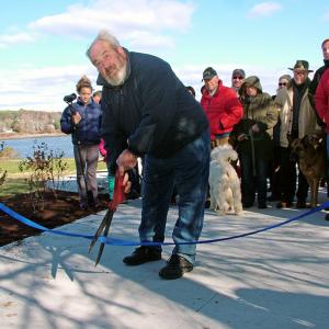 Mayor Walter Ash cuts the ribbon at the south end of the Belfast Harbor Walk during a grand opening ceremony, Nov. 9. (Photo by Ethan Andrews)