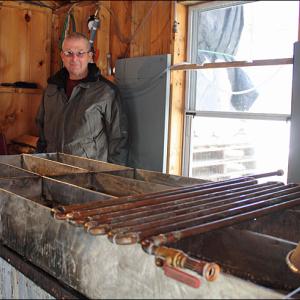 Hobby maple syrup producer Tom Cox of Rockport inside his sugarhouse near Simonton Corner Tuesday. Last year his boiling operation yielded 46-1/2 gallons of syrup. This week, the cold has stymied his progress due to hundreds of gallons of frozen sap. (Photo by Holly S. Edwards)