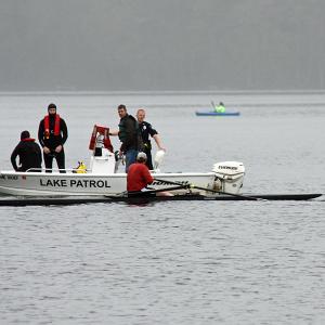 The man in the sculling boat, Jeff Foltz of Camden, who was rowing with his friend, Jim Wescott, who fell out of his own boat and went missing on Lake Megunticook Tuesday morning after 8 a.m. talks to Camden firefighters before rescue swimmers enter the water to try and find the missing man. (Photo by Holly S. Edwards)