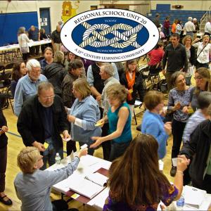 Voters at the Regional School Unit 20 public meeting Thursday pick up ballots from their town officers for a vote on raising additional local funds for 2014-15 school year. (Photo by Ethan Andrews)