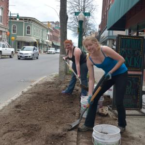 Meghan Lane, left, and Emily Lane, employees of the Grasshopper Shop, work on their day off getting the new landscaping in front of the store started. (Photo by Ron Hawkes)