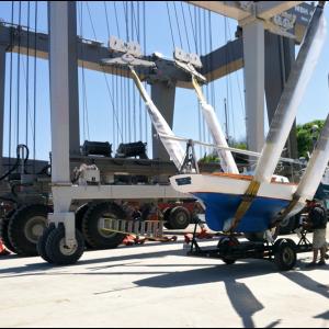 Workers at Front Street Shipyard launch a small sailboat with the company’s 160-ton travel lift. In the background, a crew readies the Shipyard’s 480-ton lift. (Photo by Ethan Andrews)