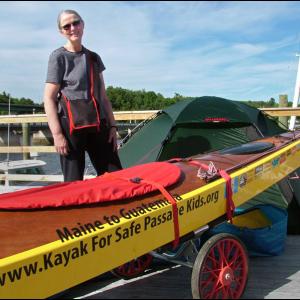 Deborah Walters with the sea kayak she is planning use for a 2,500 mile journey to Guatemala starting next month. The trip is to raise money for Safe Passage, a nonprofit working for families in Guatemala City. (Photo by Ethan Andrews)