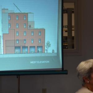 Scattergood Design architect Pamela Hawkes sits in front of the proposed 250 Main Street hotel design at Rockland’s June 10 planning board meeting, where design modifications were presented. (Photo by Lynda Clancy)