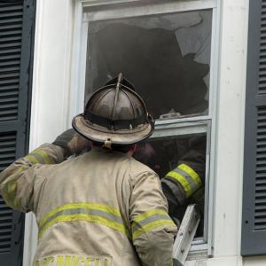 Rockland Interim Chief Adam Miceli talks to Rockport Lt. Bill Lane, who is inside the second floor bedroom where Friday morning’s fire started. (Photo by Holly S. Edwards)