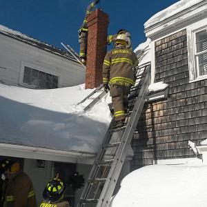 Due to the arrangement of the Yarnell’s roof lines, and the chimney, an attic ladder had to be used to allow Lincolnville firefighters to get above the chimney opening to drop a chain down and dislodge burning creosote inside. (Courtesy Lincolnville Fire Department)