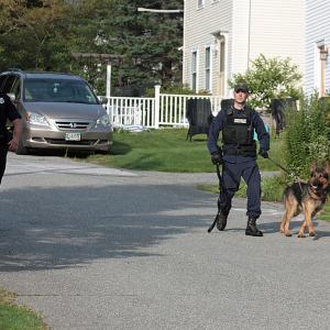 Camden Police Officer Allen Weaver Jr. and Maine State Police Trooper Erich Verhille with K-9 Clint track a suspect in the August 2014 home invasion on Maple Street in Camden. Monday, Camden police charged 22-year-old Eli Kemberling with burglary, aggravated trespassing and assault stemming from that incident. (Photo by Holly S. Edwards)