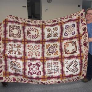 Marty Shaw, left, receives her quilt from Carolyn Herron, right, who made and donated it.