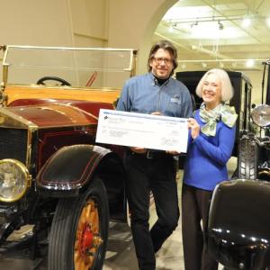 OHTM Executive Director Russ Rocknak receives a check for more than $125,000 from Dawn Swinton. Swinton's late uncle, Tom Appleton Plaisted, left the funds in trust for OHTM. Russ and Swinton elected to execute the check passing in front of the Museum's 1913 Rolls-Royce Silver Ghost which originally belonged to Plaisted's ancestor, Alice Longfellow.