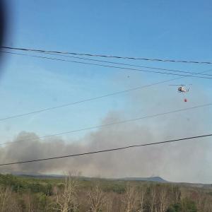 A Maine Forest Service helicopter flies over the fire in Searsmont, which was reported to Waldo County Regional Communications at 4:53 p.m. Thursday, May 7. (Courtesy Bob Hall)