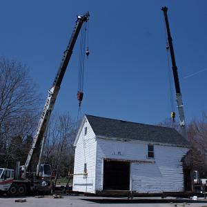 The barn behind 59 Elm St., a house owned by the First Congregational Church of Camden that has served as a residence for Coastal Opportunities tenants for 25 years, is lifted from its foundation Monday morning and moved next door to 63 Elm St., a parcel owned by Denise Pukas. (Photo by Holly S. Edwards)