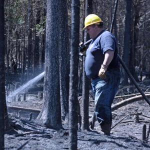 Firefighters from Liberty, Montville and Morrill joined Searsmont early Thursday evening to battle a woods fire off Choate and Jackson roads in Searsmont, while 56 volunteers from more towns across Knox and Waldo counties joined the continued effort Friday. Pictured is Hank Lang of Northport and Lincolnville fire departments. (Photo by Holly S. Edwards)