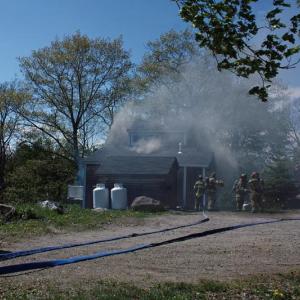 A fire at 40 John St. in Camden Thursday afternoon caused damage to an exterior wall and inside in the kitchen, both at the back of the home that sits close to the road. (Photo by Holly S. Edwards)