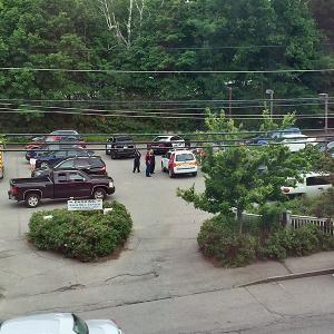 Camden Police and North East Mobile Health Services EMTs respond to an unattended death in a tract of woods separating the Knox Mill and Rite Aid parking lots in downtown Camden. (Photo by Holly S. Edwards)