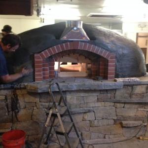 The wood-burning oven, made of granite and clay, is constructed by the community, and is a signature part of every Flatbread Company restaurant. (Photo courtesy Allen Mitchell)