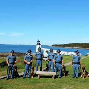 Pictured from left are Officer Jamie Fanning & K9 Aki, Trooper Barry Meserve & K9 Doyle, Trooper Jeffrey Taylor & K9 Oscar, Corporal Seth Edwards, Sergeant Scott Dalton & K9 Haro. Trooper Adam Schmidt & K9 Ibo, Trooper Andrew Levesque & K9 Vitz, Deputy Merl Reed & K9 Frankie. (Photo courtesy Maine Department of Public Safety)